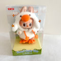 A Pop Mart Forest Fairy Tale collectible plush toy inside its original clear plastic packaging box, featuring a character in a white bunny costume with orange accents.