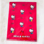 A bright pink Hello Kitty file folder with a glossy finish, featuring printed illustrations of Hello Kitty in blue and yellow outfits, bows, and the 'HELLO KITTY' logo at the bottom.