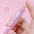 A hand holding a pink Hello Kitty retractable mechanical pencil, against a solid pink background with a '0.5 mm' size callout graphic.