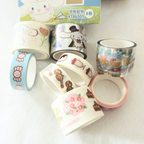 A set of Sanrio-themed washi tapes with various cute character designs, displayed alongside their product packaging box on a white background.