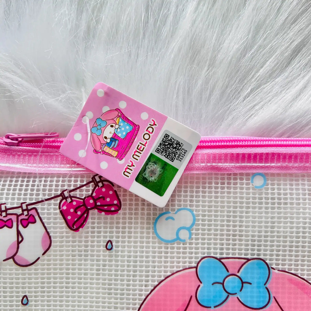 A close-up of a pink zippered pouch. The pouch has a printed pink cartoon label that reads 'my MELODY'.