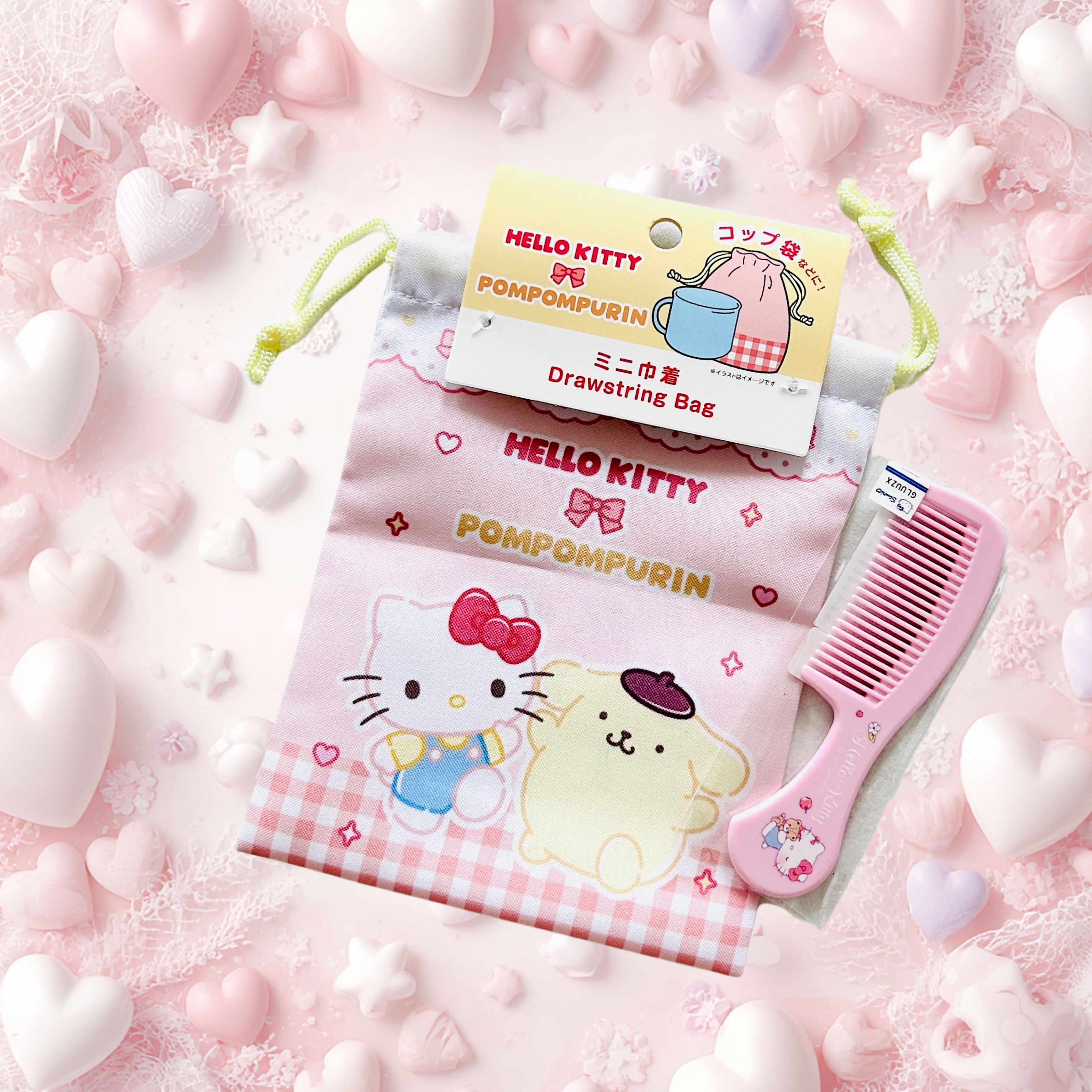 A Hello Kitty Pompompurin drawstring bag in pink gingham with a pink comb. The bag has a hanging paper tag reading Hello Kitty and Pompompurin.