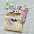 A small Hello Kitty-themed pouch with a yellow-and-white gingham pattern and a cartoon illustration.