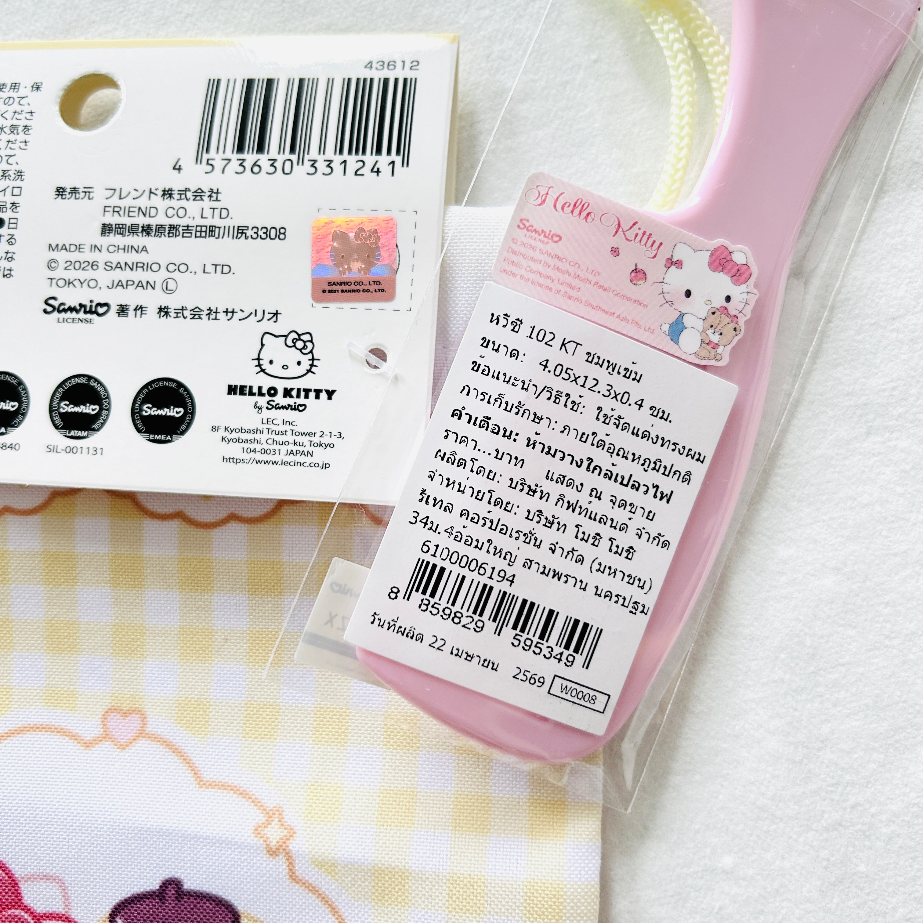 A Hello Kitty hair comb's product information in Thai, and the drawstring bag package shows certificate mark.