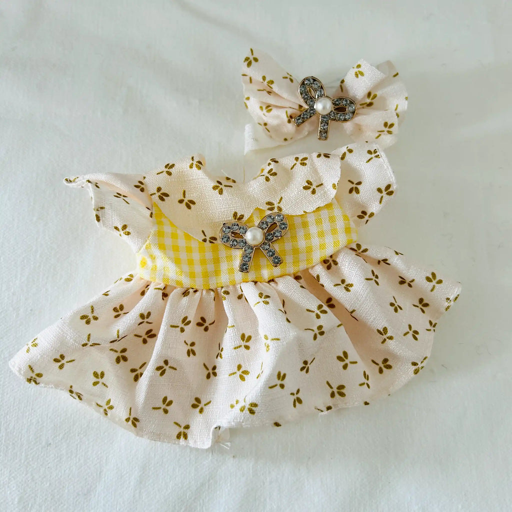 A Labubu doll yellow floral dress with white gingham bodice, and a matching bow headband with a rhinestone bow and pearl.