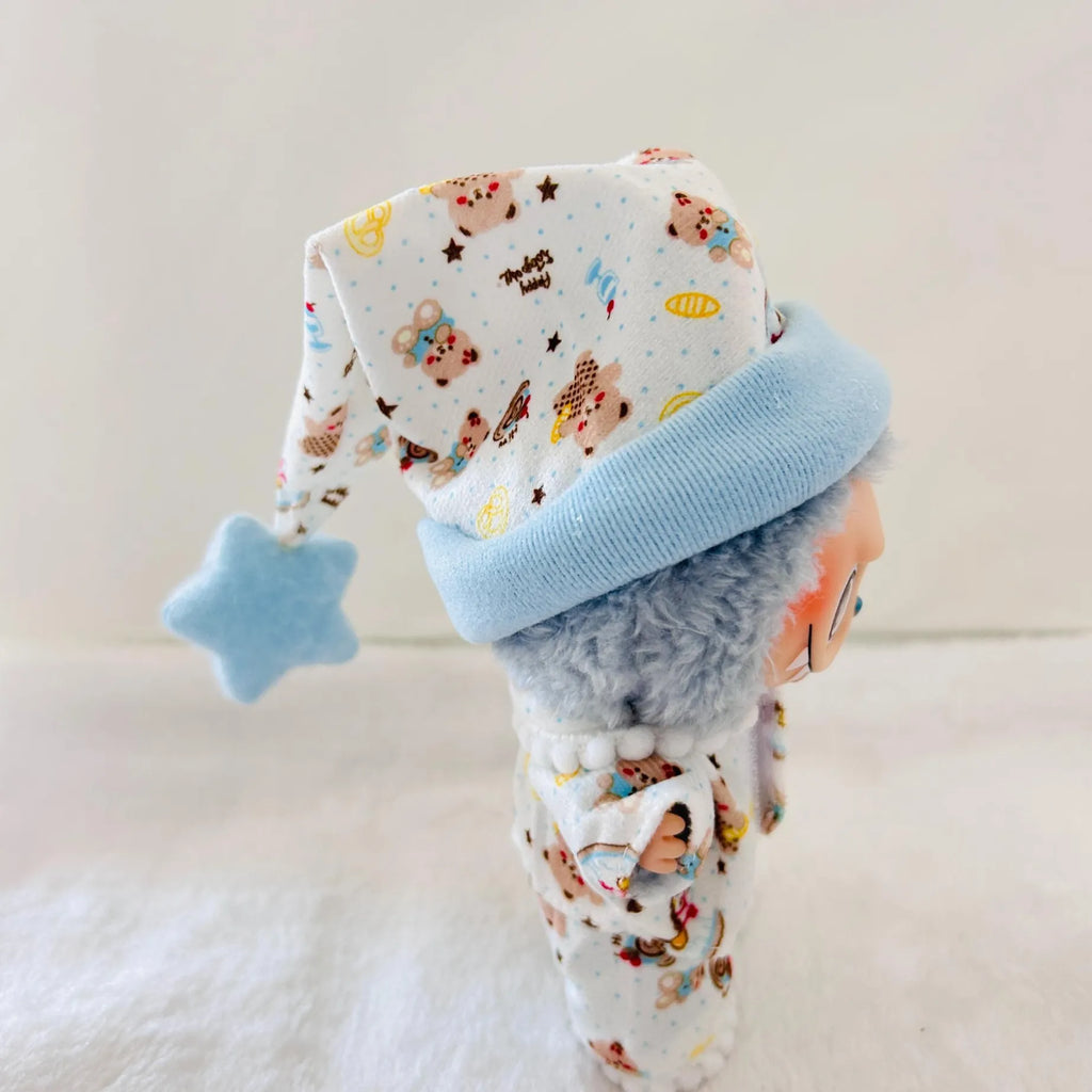 A Labubu doll wearing a white patterned pyjamas set with a light blue cuff and a matching light blue star-shaped hat.