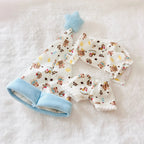 A back view of a Labubu doll pyjamas set including a top and pants with bears patterned, with a light blue hat. 
