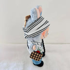 A Labubu plush toy dressed in a black and white striped knit hat, a white polka-dot top, blue jeans, and black shoes.