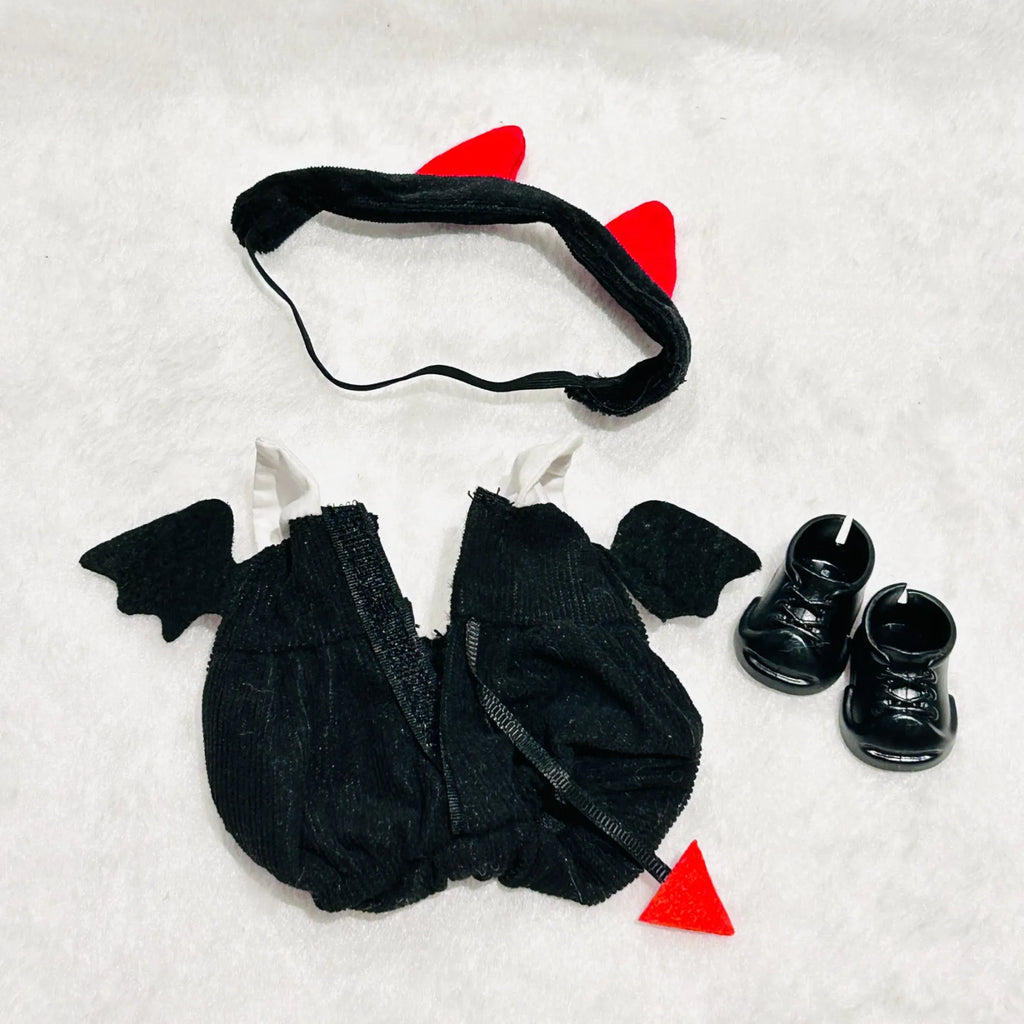 A flat-lay back view of a Labubu costume set, featuring a red cat-ear headband, a black bat-wing dress, a small red tail, and black booties.