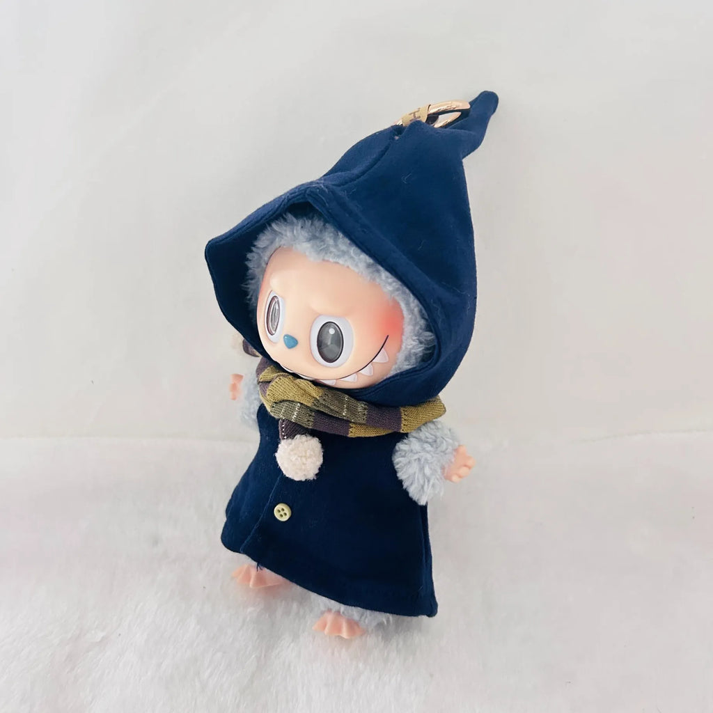A Labubu plush doll wearing a dark navy blue pointed hooded coat with a plaid scarf.
