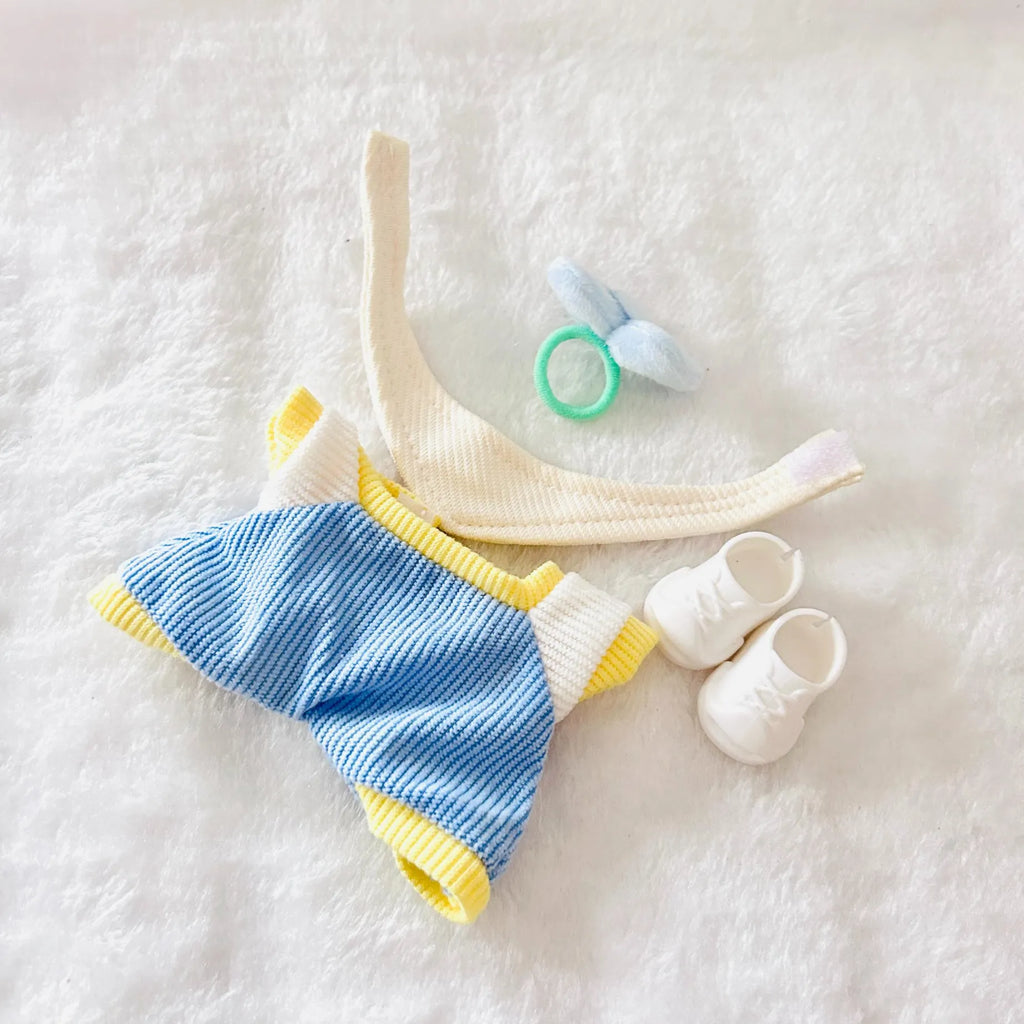 Back view of a doll outfit including a blue jumpsuit, and a pair of small white bootie shoes.