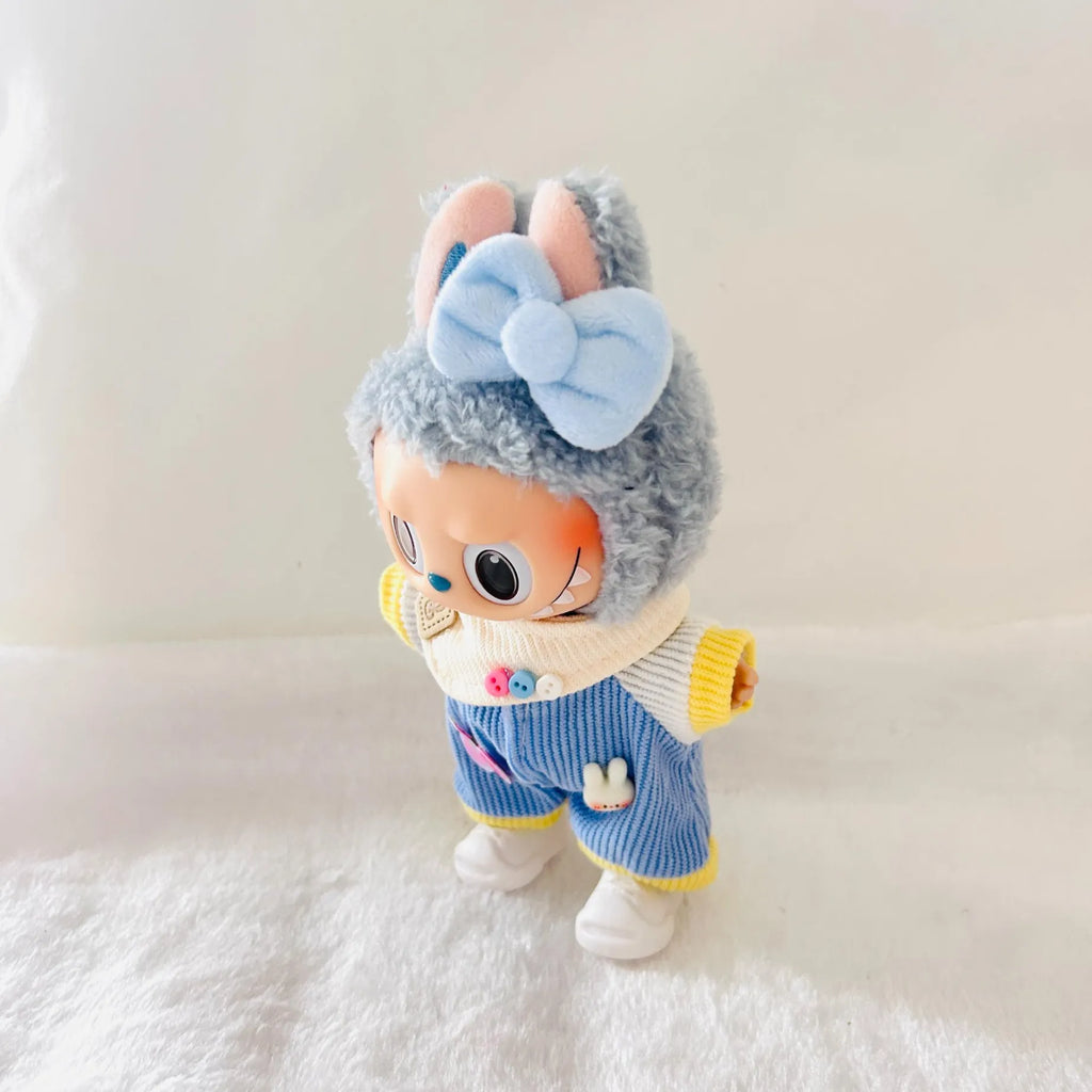 A Labubu plush doll wearing a light blue bow, and a blue striped outfit with yellow trim.