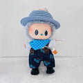 A cute doll character wearing a blue woven hat, a blue polka-dot bandana, dark blue floral overalls, and black shoes.