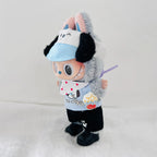 A plush toy dog dressed in a light blue visor, white bib with red polka dots, black pants, and black shoes.