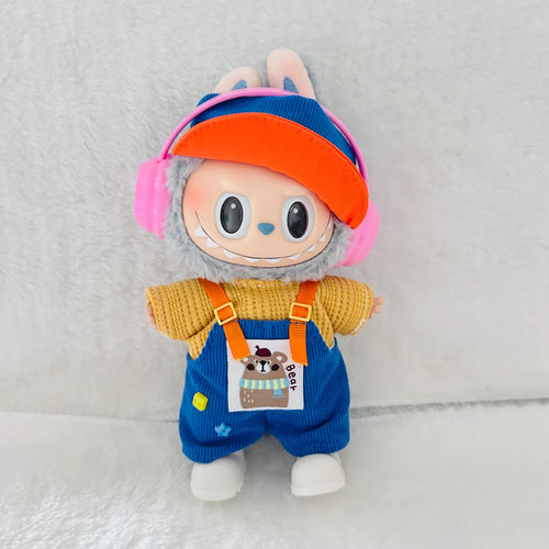 A Labubu plush toy doll dressed in a yellow knit top, blue corduroy overalls, an orange visor, and pink headphones.