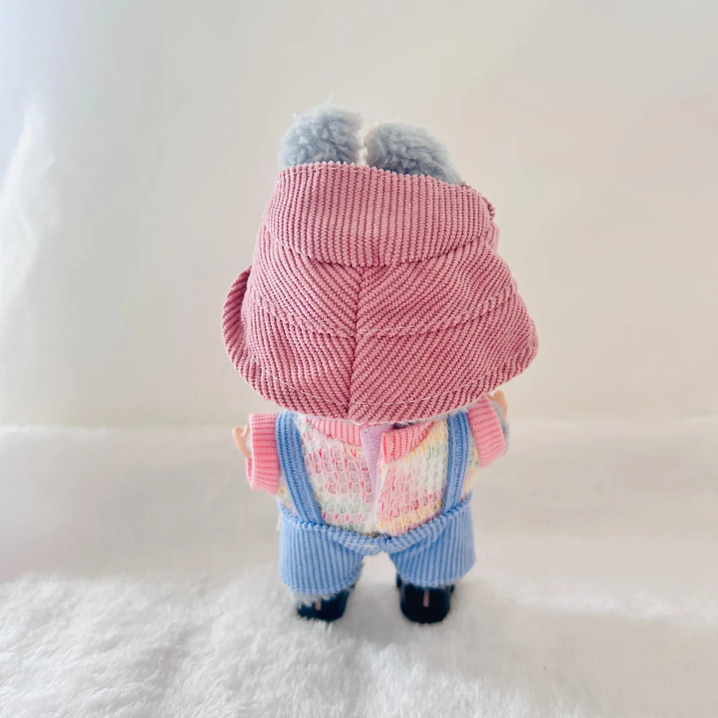 A back view of a Labubu wearing a pink corduroy hat, a pastel multicolor knit top, and blue corduroy overall.