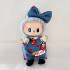 A Labubu plush doll with a blue bow decorated with red hearts. The doll is wearing blue denim-style overalls with red hearts, strawberry patches.