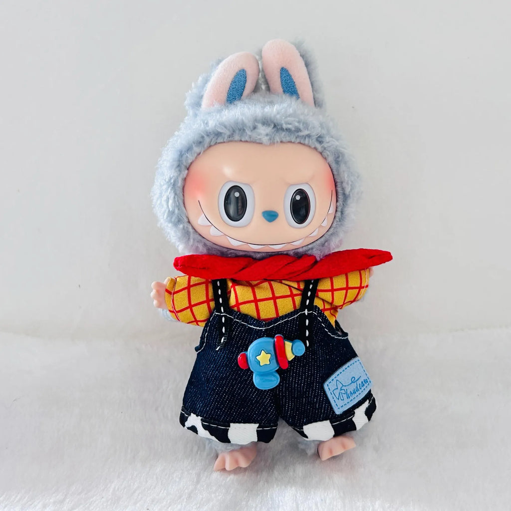 A Labubu plush doll wearing a red and yellow plaid shirt, dark blue denim-style overalls with a blue toy blaster patch.