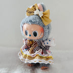 A Labubu plush doll wearing a dress with lace, gingham, and patterned fabric details.