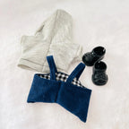 A styled flat-lay of a two-piece knit outfit for a Labubu doll, featuring a light grey  hoodie and a navy blue corduroy overall and black booties.