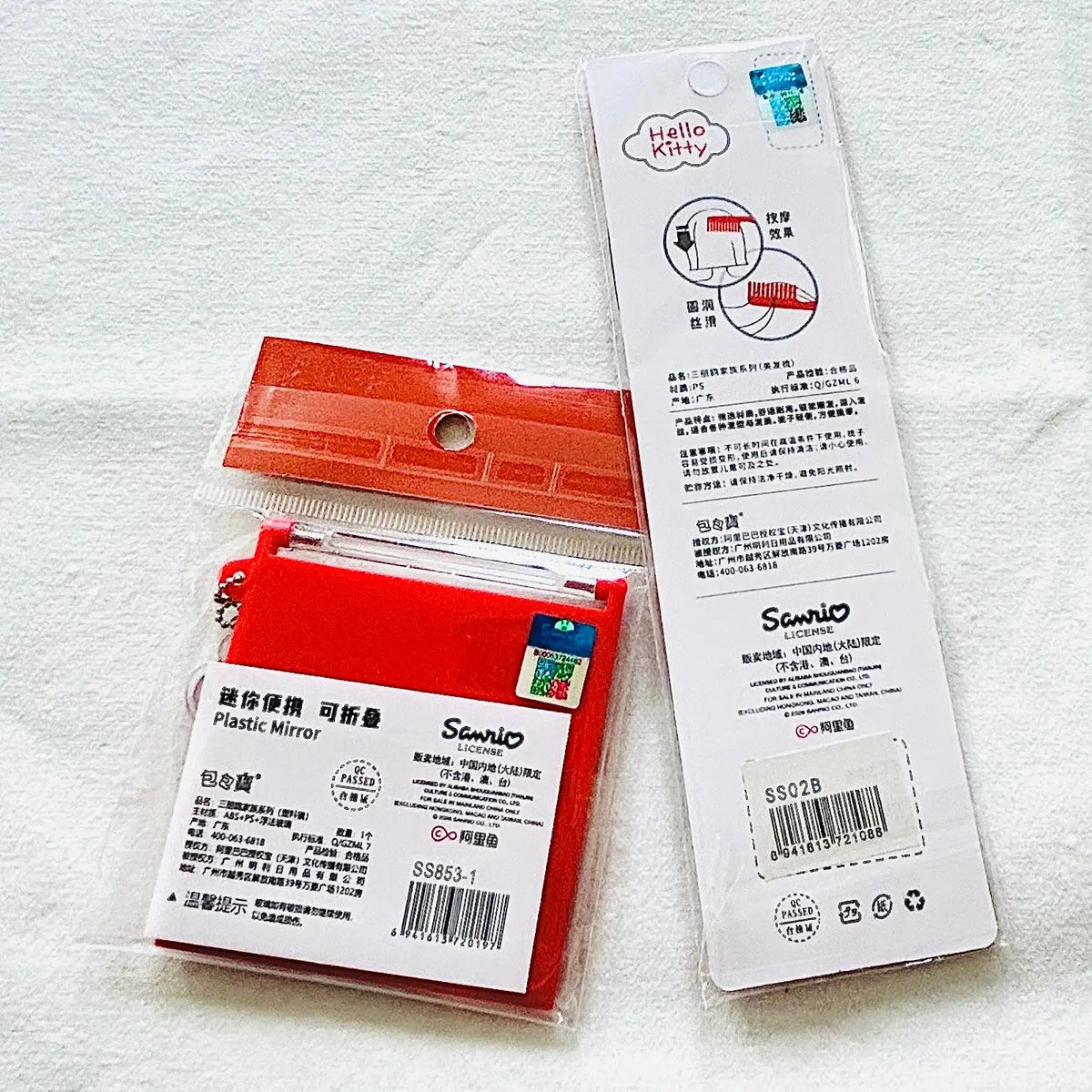 A pack of red plastic mirrors with white product labels and an instruction card, displayed on a textured white fabric background.