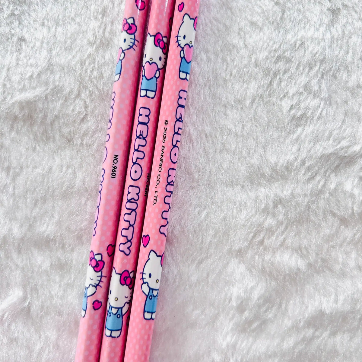 Three pink Hello Kitty pencils with cute character prints and polka dots.