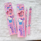 Two pink Hello Kitty pencil boxes with three matching pink pencils displayed on a white textured fabric background.  