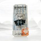 A packaged plush toy resembling a gray furry character wearing a black shirt with blue stripes and the word 'HIRONO' on the front, mounted on a printed backing card.