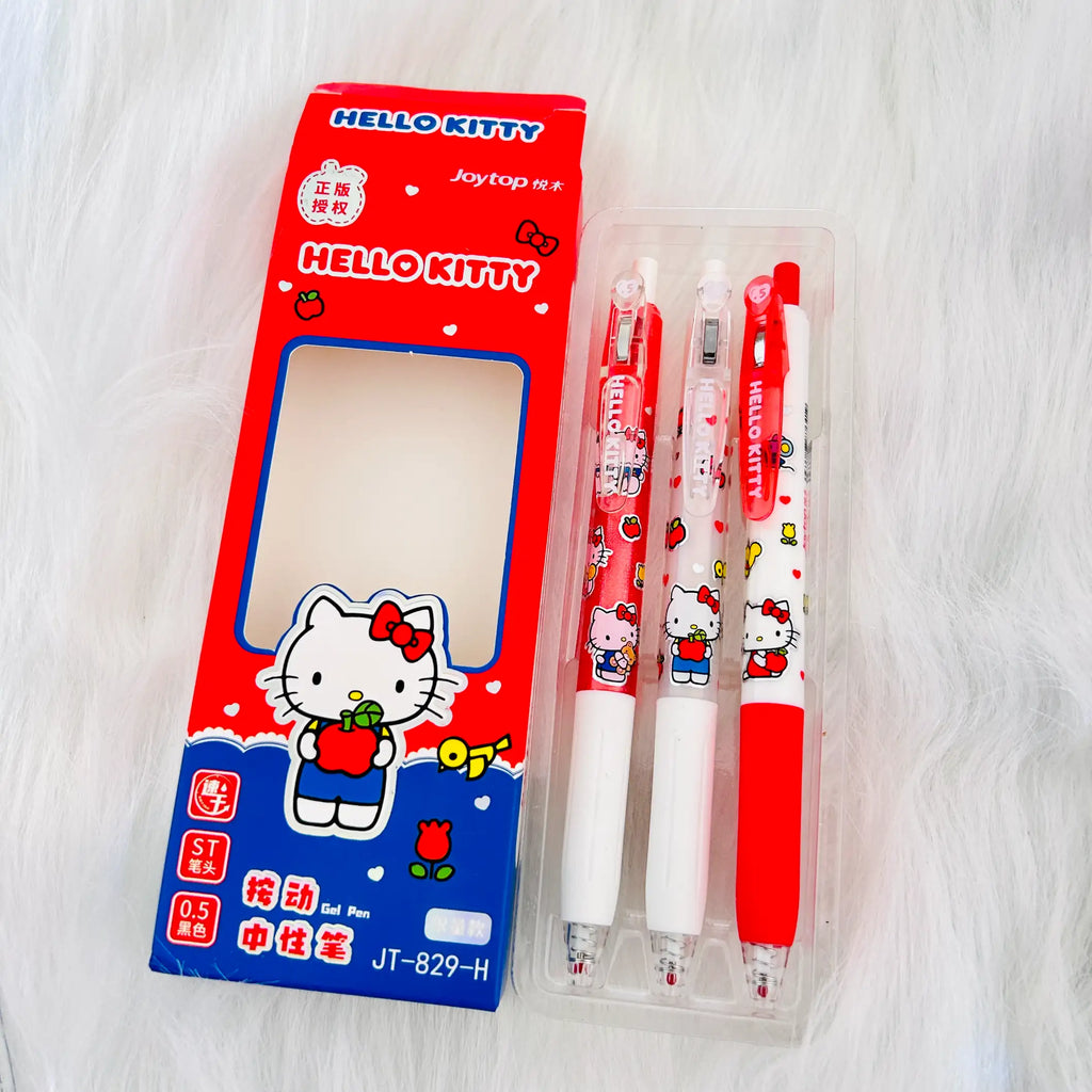 Hello Kitty themed Joytop pen set with its retail packaging, displayed on a white faux fur background. The set includes a red and blue box with a clear window showing three pens inside a clear plastic case.