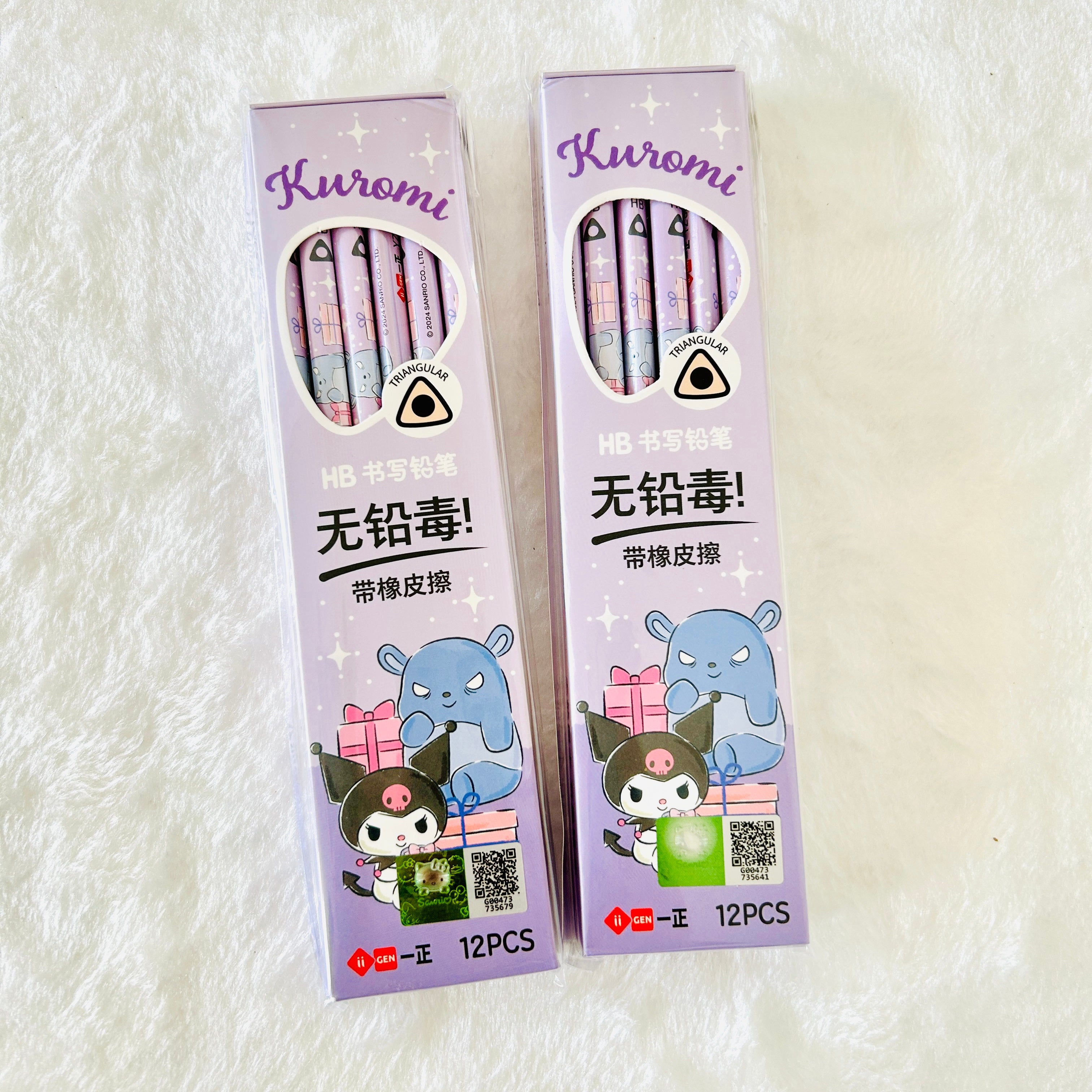 Two boxes of Kuromi HB writing pencils with a white textured background. The packaging is light purple with cartoon illustrations of Kuromi.