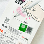 A close-up of a white Hello Kitty branded product card featuring a hand illustration holding a transparent pen with pink swirl graphics, Chinese text, QR codes, and a green Hello Kitty logo patch.