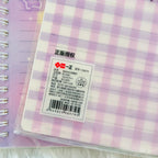 A close-up of a purple and white gingham notebook's product information label.