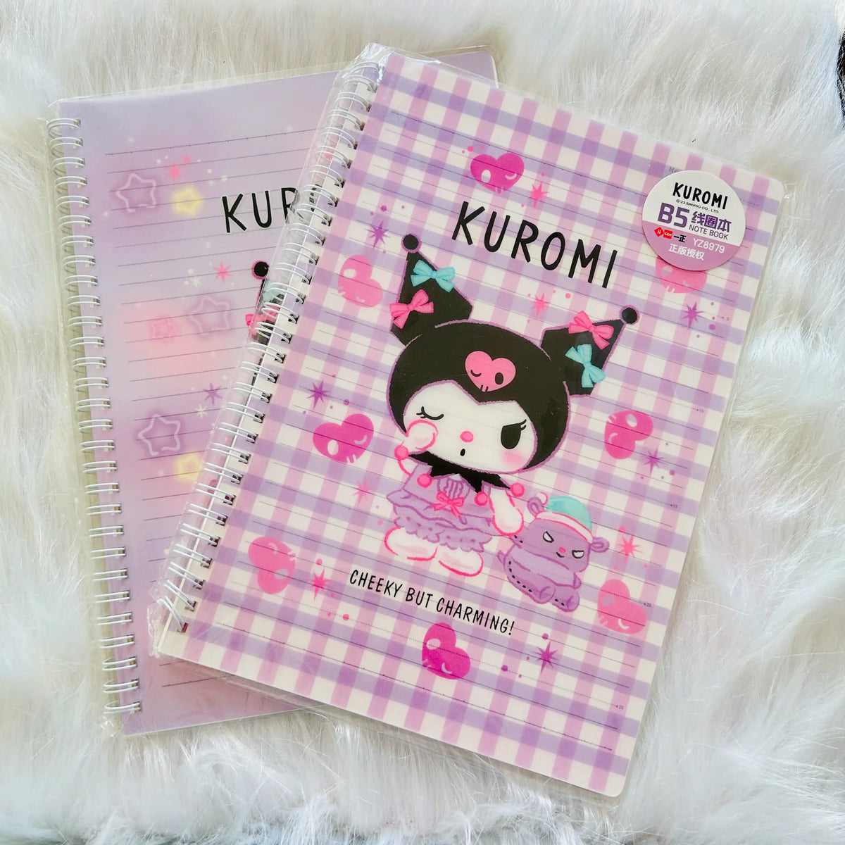 A Kuromi-themed spiral notebook with a pink and white gingham cover, featuring a Kuromi character illustration.