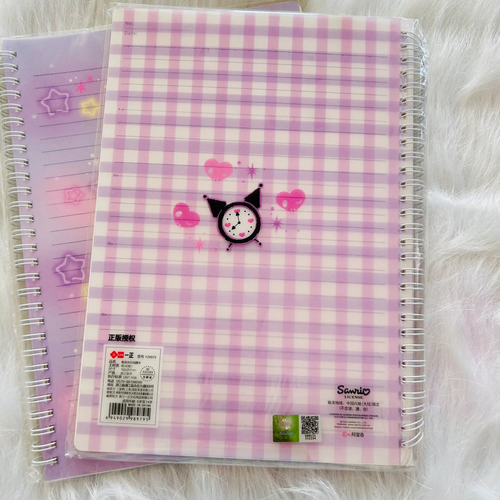 A close-up of a spiral-bound notebook with a pink and white gingham patterned cover, featuring a Sanrio License sticker.