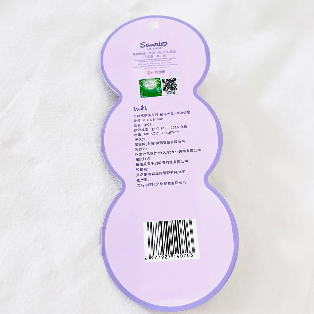A light purple huggie-shaped product tag or packaging insert with printed text, a barcode, and a small green square graphic, photographed on a white textured fabric background.
