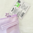 A close-up of a light purple canvas zippered pouch with a matching star-shaped zipper pull, shown next to its white product tag featuring the brand name 'Sanrio'.