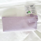A light purple canvas zippered pouch with a wrist strap, shown with its retail tag on a white fabric background.