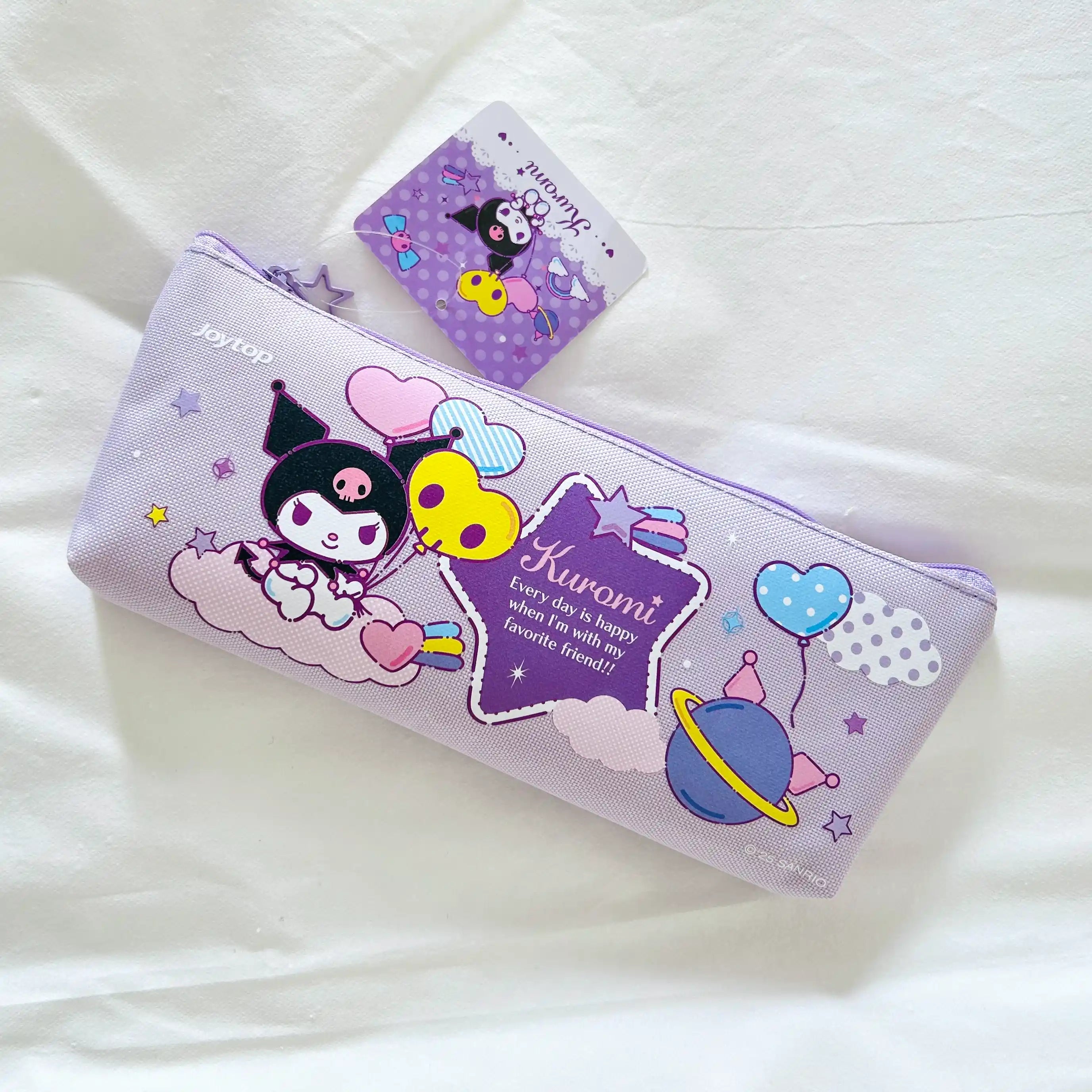 A lavender Kuromi-themed pencil case with a matching card, photographed on a white fabric background.