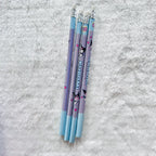 Four Kuromi-themed pencils with light blue and lavender-purple bodies, decorated with cartoon characters and the word 'KUROMI'.