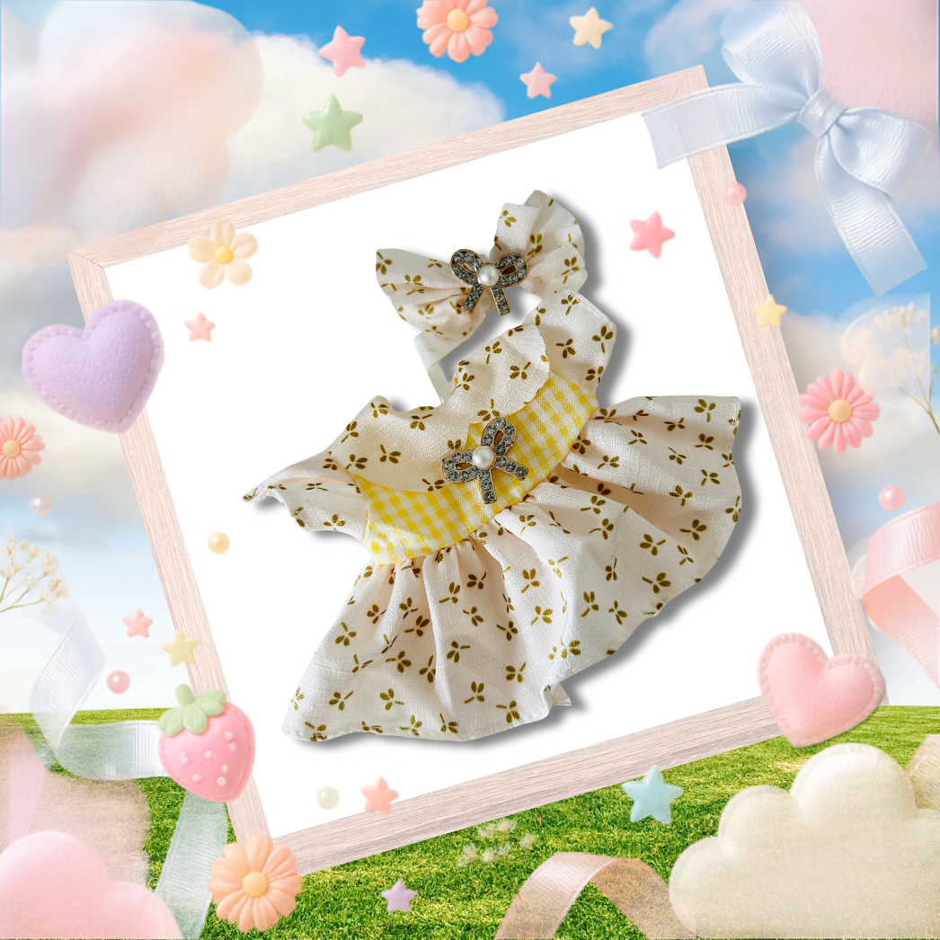 A Labubu doll-sized white dress with a yellow floral print, a yellow-and-white gingham waist sash, and a matching bow headband.