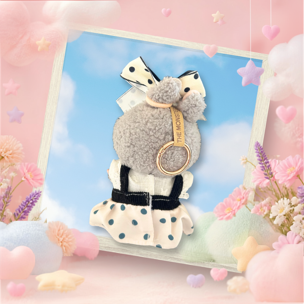 The back view of the clothing set that include black polka dot pinafore and oversized pearl bow