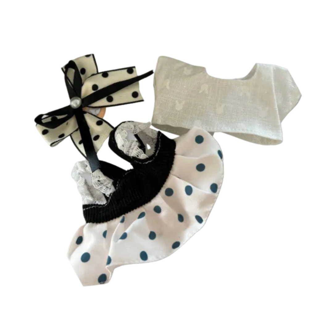 The front view of the clothing set that include black polka dot pinafore and oversized pearl bow