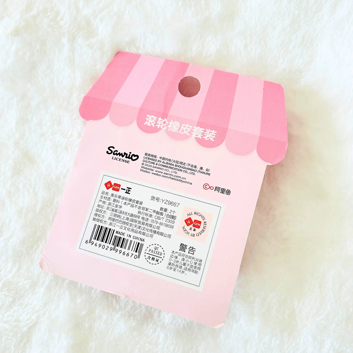 Sanrio rolling rubber accessory packaging card, featuring a pink and white striped awning design with product details and barcodes.