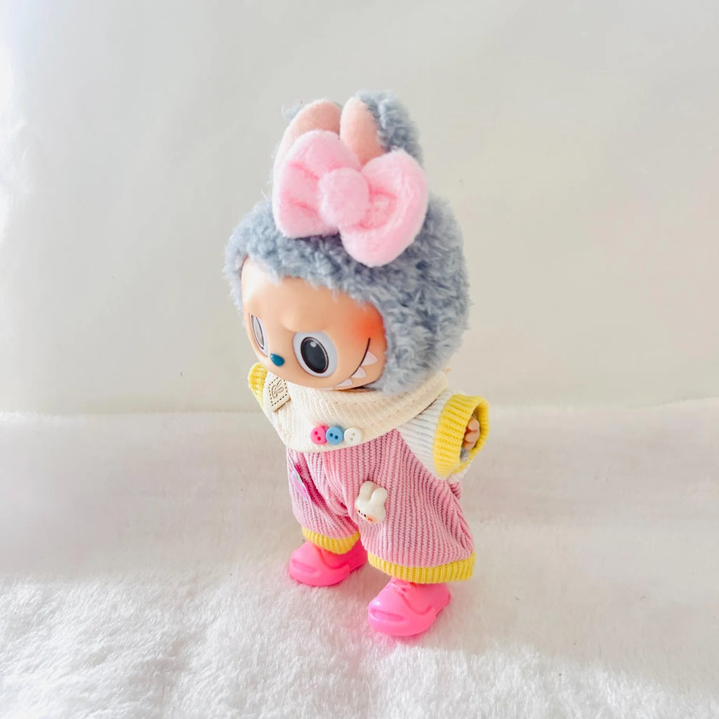 A Labubu doll wearing a large pink bow, and a pink striped outfit with yellow trim.