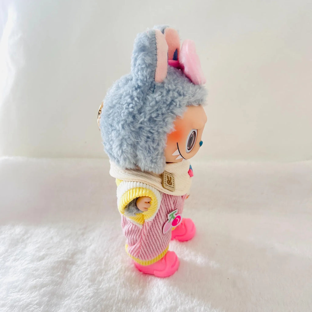A Labubu plush doll with pink bow, wearing a pink striped jumpsuit and bright pink shoes.