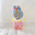 Back view of a Labubu plush doll wearing a pink striped jumpsuit.  