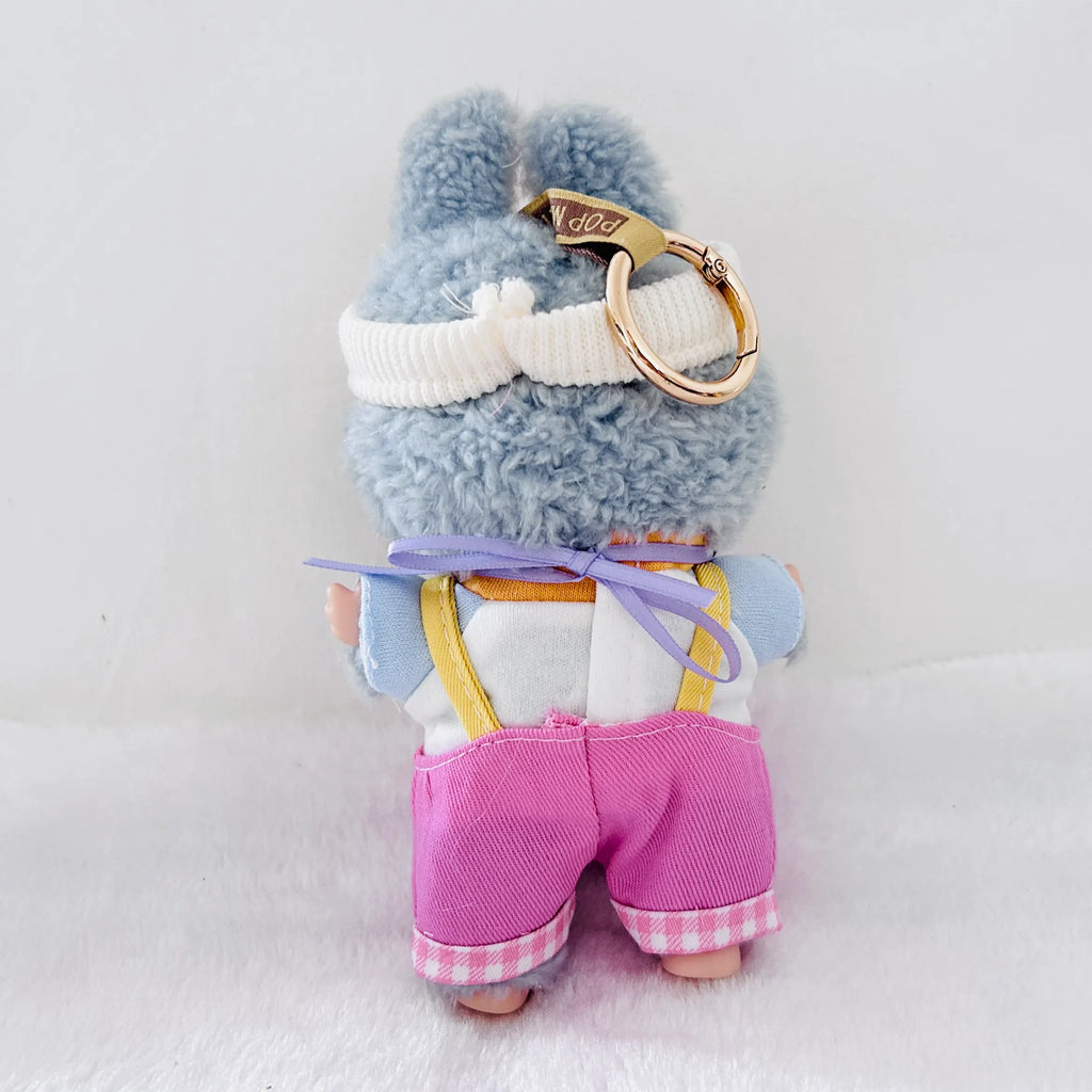 Back view of a Labubu plush doll wearing a white top and pink overalls.