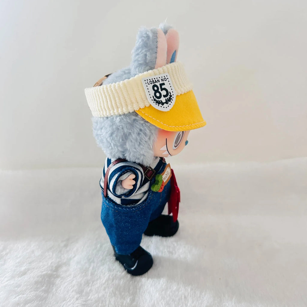 A Labubu doll plush wearing a blue denim-style overalls, and dark shoes