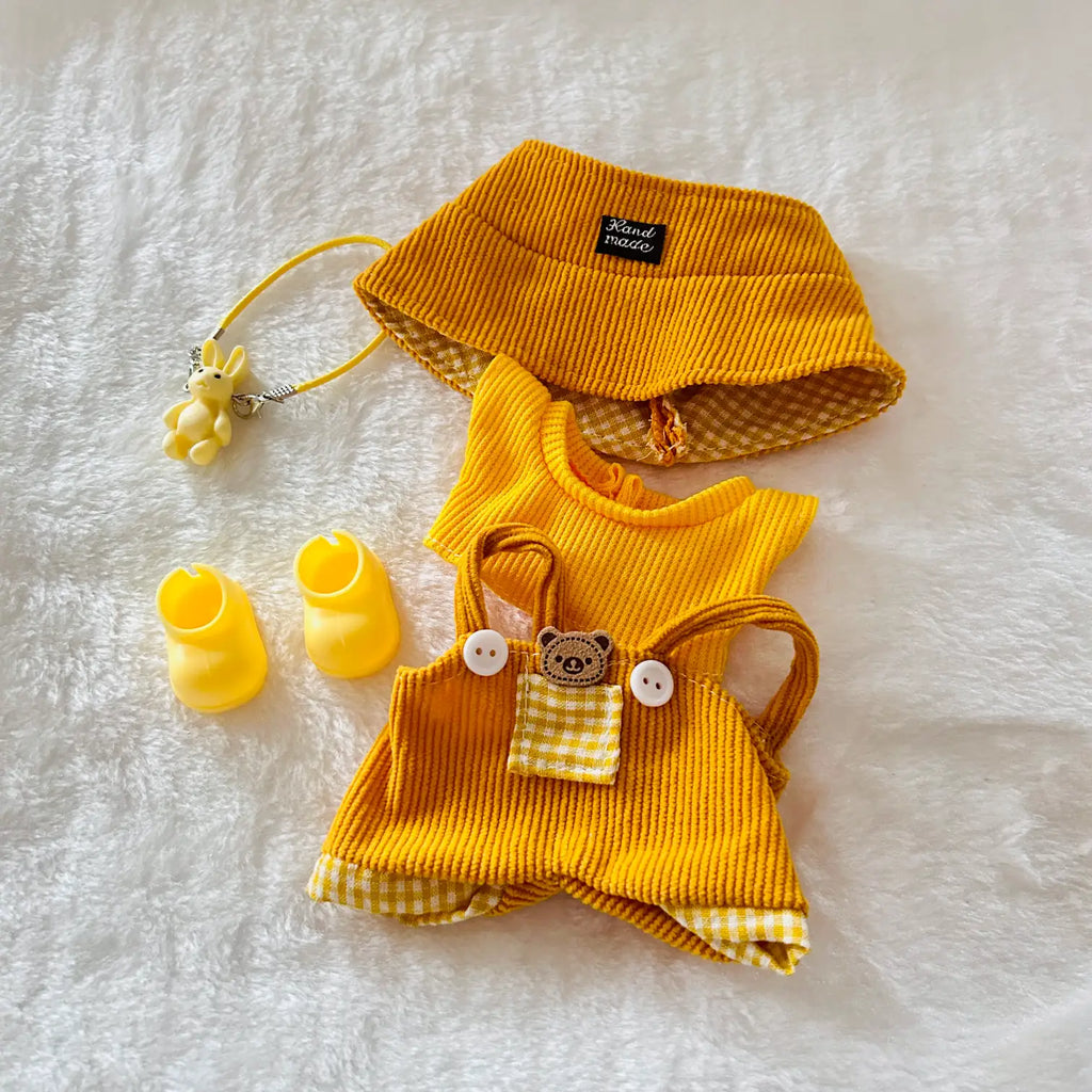 A yellow and white gingham pet outfit set, including a yellow corduroy hat, matching top, shorts, booties, and a small yellow accessory with a bunny charm.